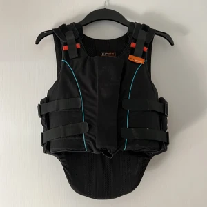 Ridväst  - Ridväst som blivit för liten, aldrig avramlad i. Skött försiktigt. Blivit för liten bara och ingen användning hemma. Storlek Y5 regular. Chest 71-78 cm. Level 3 