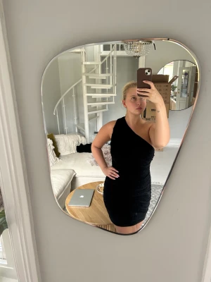 Glittrig klänning  - En svart glittrig one-shoulder klänning från HM i storlek 38. Super fin, endast använd 2 ggr. 