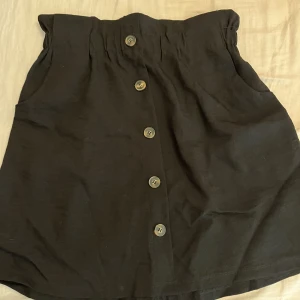 Svart kjol med knappar  - Aldrig anävnd 
