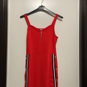 Röd klänning med knappar - Super fin röd klänning med dragkedja vid bröstet och knappar längs med benen. Använd ungefär 5 ggr och ser som ny ut. Inga defekter förutom en knapp som är borta men det är inget som syns.  Skriv i DM för frågor, Köparen står för frakten.pris kan diskuter