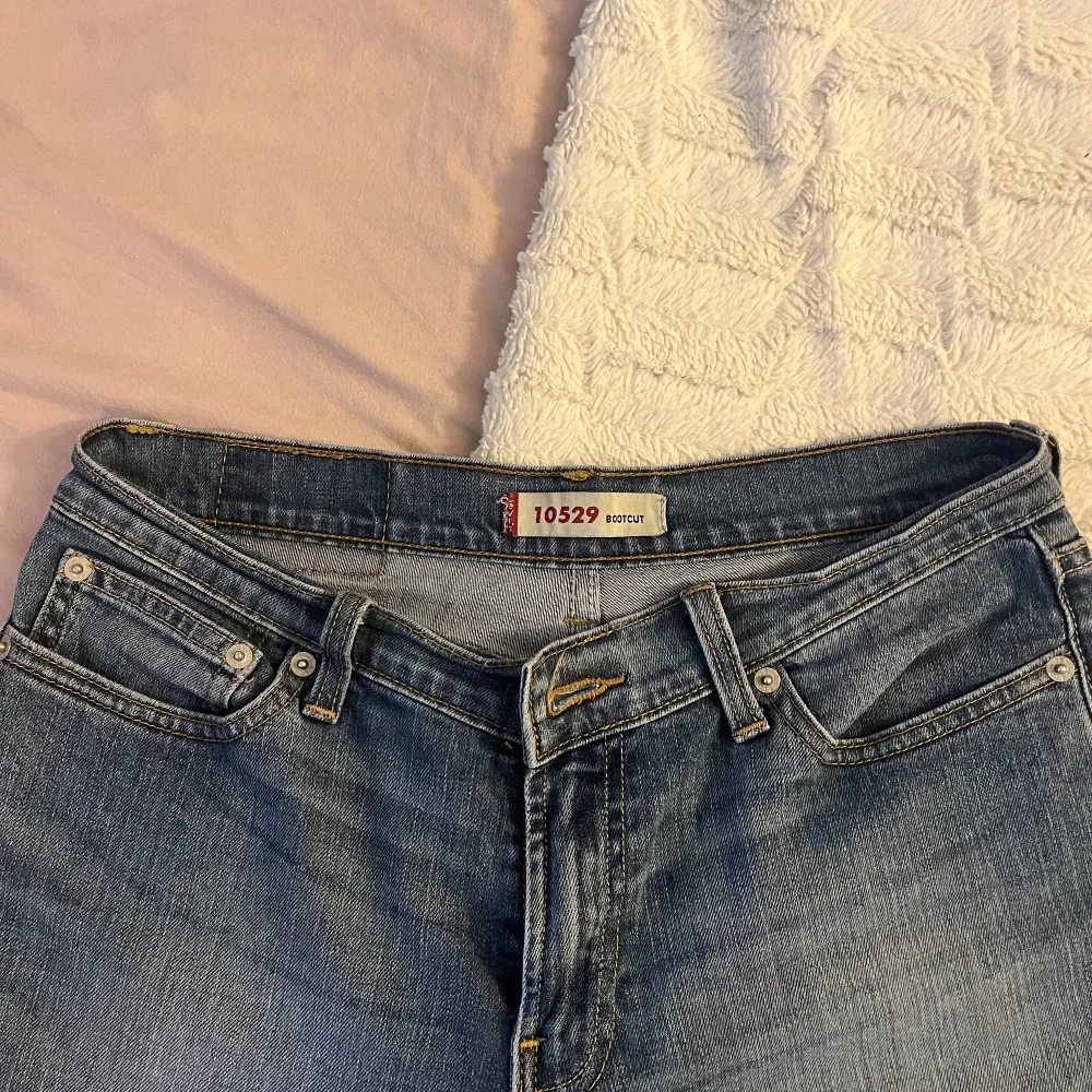 fina levis jeans som är bootcut, i modell 10529. köpte här på plick, de är lågmidjade och sitter perfekt men tyvärr ej kommit till användning. de har lite slitningar, se bild 2 💕. Jeans & Byxor.