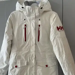 Vit skidjacka men röda detaljer från helly hansen.✨  • Storlek M • Använt skick  • Säljes då den blir för liten. • vind- och vattentätt 