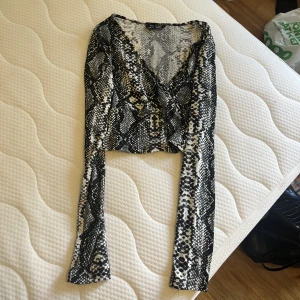 Topp - Topp i ormliknande motiv.  Knappt använd. Storlek S 