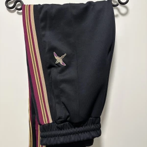 Axel Arigato byxor  - Säljer ett par trackpants från Axel Arigato i mycket gott skick. Byxorna är i storlek S, men funkar fint på M som jag egentligen har, men även L. 