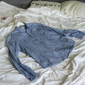 Säljer en ljusblå skjorta i från lee med passformen slim fit. Denna skjorta har metall knappar tillskillnad från de flesta skjortor med plast knappar.