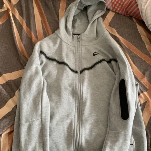 Nike Tech Fleece - org pris 1100 men på rabatt. Denna virala koftan är för ungdomar åldern 12-13. Den är i ren skick, oanvänd. Den är grå, stilig och populär kofta för att göra ungdomar känna sig varma och sköna😉. Säljer från erfanheter av att vilja ha koftan 😁