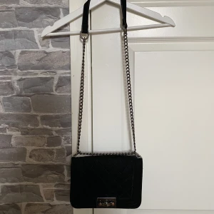 Elegant handväska i pläderat material. - Svart elegant handväska i pläderat material. I fint skick.  Köpt för 399kr, säljer för 49kr.