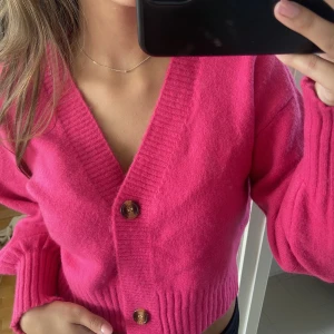 Stickad kofta/tröja - En rosa stickad kofta/tröja. Går att ha både knäppt och uppknäppt. Använd 1 gång, står ingen storlek men jag är en XS/S