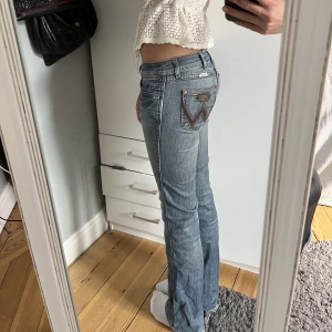 Lågmidjade Blå Jeans  - Säljer dessa ascoola Lågmidjade jeans från Wrangler💗🤩 de här är några av mina favoritjeans som är köpta second hand i Amsterdam. De är storlek W27 L34 och passar mig som har storlek 34, och ca 168 cm lång. De har några små DEFEKTER skriv privat för bild!
