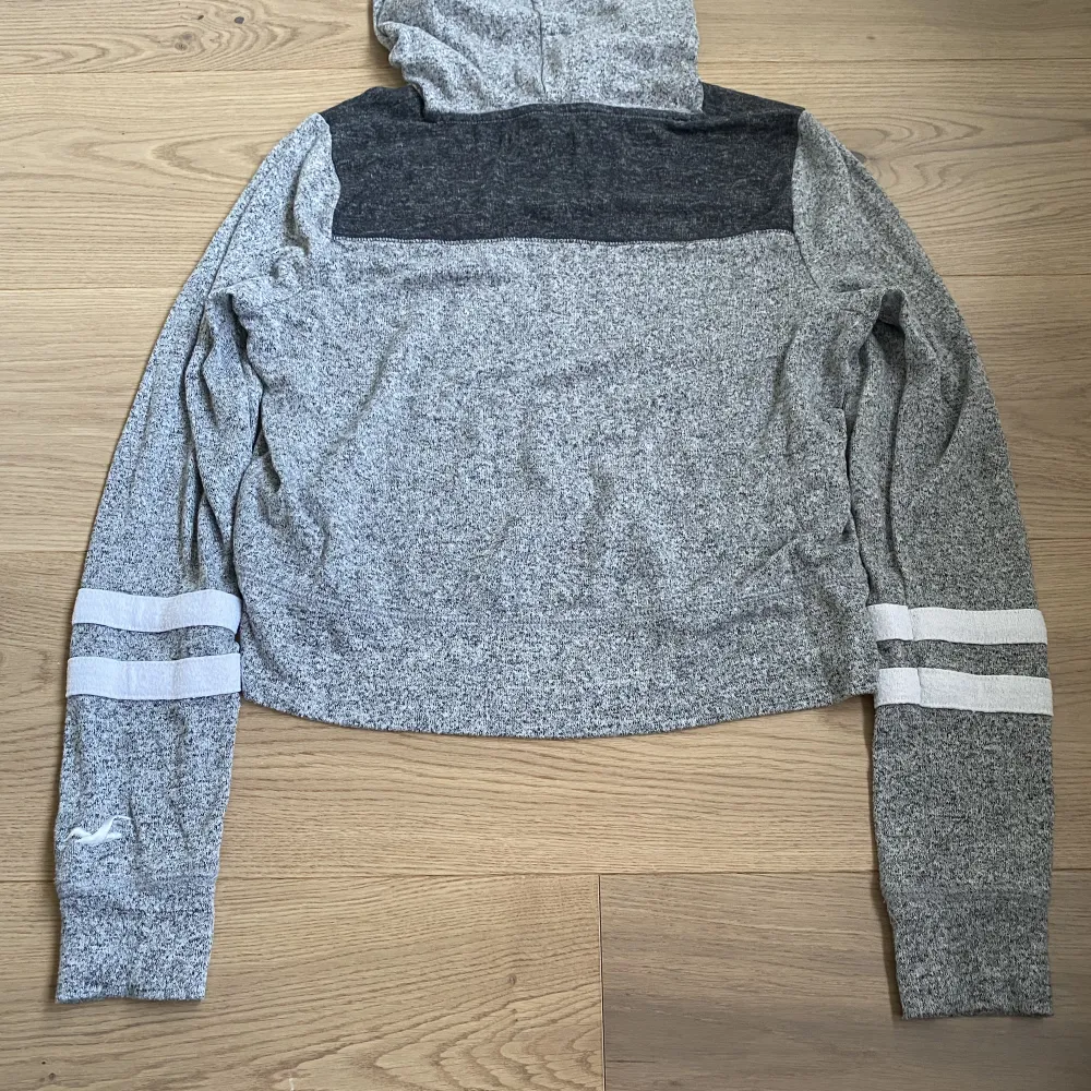 En grå hoodie från Hollister i storleken XS. Säljer den för den är för liten. Ganska tunn och stickad. Pris kan diskuteras!🙌. Stickat.