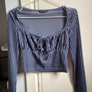 Blå topp - Blå kort långärmad topp som är jättefin. Den är aldrig använd men har endast provat eftersom den inte passar mig. Så den är i nyskick. 💗Den är urringad med en rosett som en fin detalj