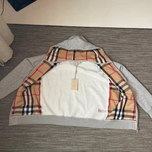Burberry zip hoodie - Säljer nu min riktigt snygga och trendiga burberry hoddie med de klassiska mönster inuti, det finns inga som helst defekter funderar på å sälja om jag får rätt pris för den. Ja köpte den av en kille på plick men köpte inte med något og. Kan gå ner i pris!