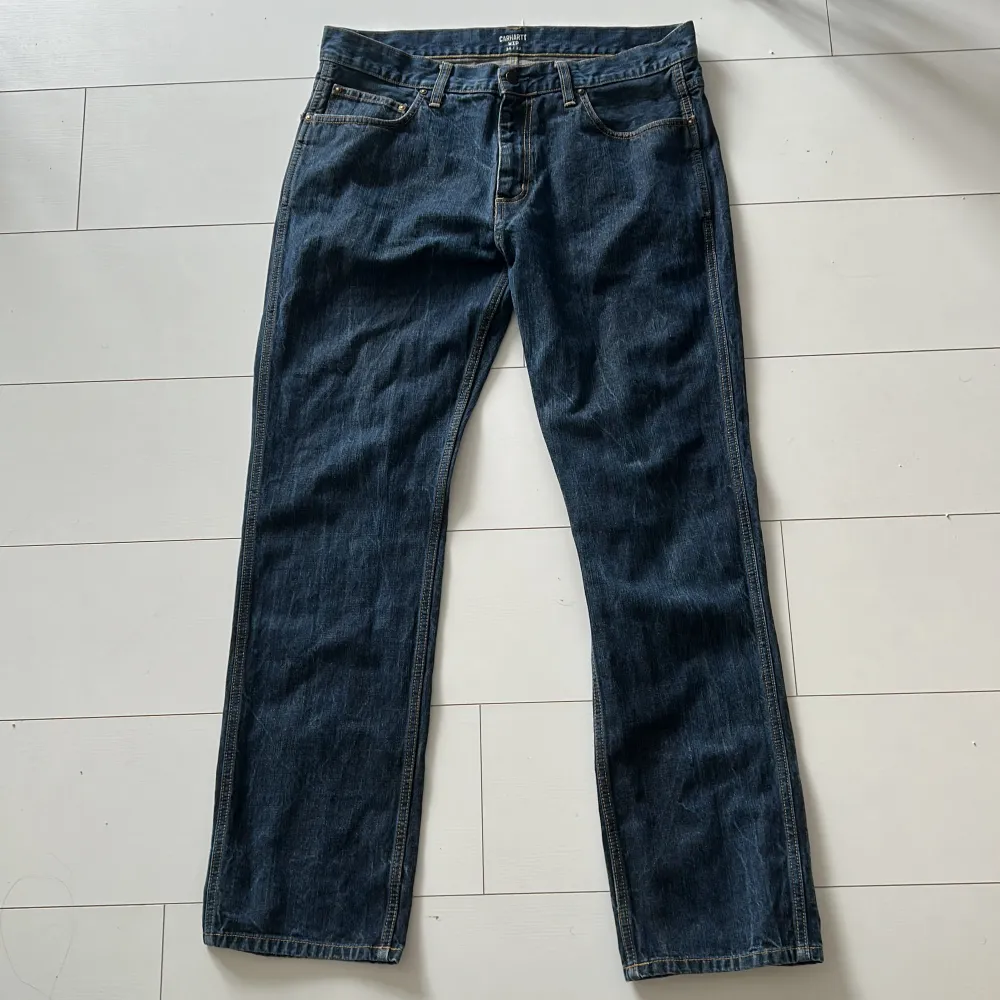 Carhartt WIP Jeans i mörk blå färg. Bra skick förutom ett litet hål på höger sida av byxorna.  Storlek: 34/32 . Jeans & Byxor.