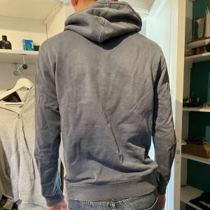 Blå hoodie - Vanlig hoodie. Lite missfärgad och sliten med hål under armarna 