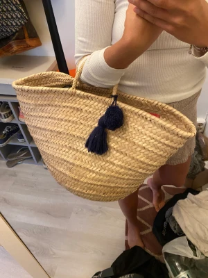 Strandväska  - Så fin strandväska med blå tassels, stor så man får plats med det man vill ha med. Köpt i Palma förra sommaren och knappt använd. 