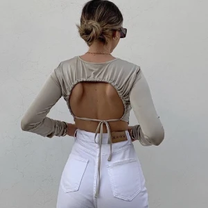 Topp med öppen rygg - Skinande topp med öppenrygg med knytning. Använd max 2 ggr. Köptes för 269kr säljer för 100kr 