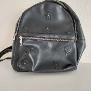 Svart ryggsäck  - Svart ryggsäck från en resa utomlands, använd några gånger. Den är i bra skick. Har ett fack på framsidan och ett på insidan av väskan. 