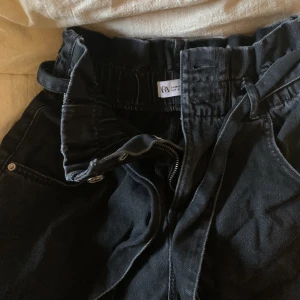 Jeans shorts - Mörkgråa jeansshorts från Zara med vida ben och fickor fram- och baktill. Storlek 36 men passar även mindre då den har en elastisk midja med knytning, så passar även mig med strl 32/34.