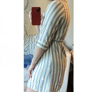 Kortare blågrå/vit sommarklänning! - En väldigt bekväm blågrå/vit sommarklänning, storlek 38, justerbar snörning i midjan, trekvartsärmad, knappar längs framsidan, bröstfickor