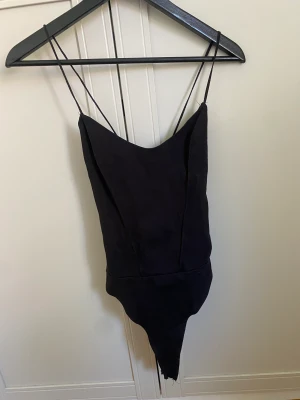 Body med snörning i ryggen - Body med öppen rygg/snörning i ryggen. Snygg passform, funkar som både storlek S och M tack vare snörningen. Storlek S från Zara. Slitna sömmar runt ryggen som inte påverkar hållbarheten.