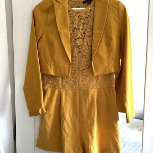 Kort byxdress med fickor - Sitter jättefint och har öppen rygg. Säljs med eller utan kavaj. (Kavajen är ett annat märke)