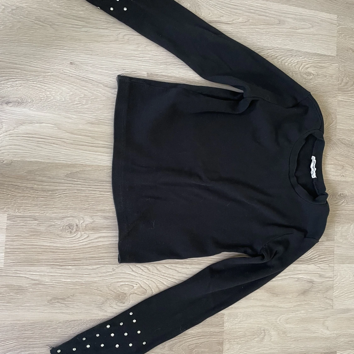 Blus med vita sten på armarna