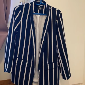 Mörkblå kavaj - Säljer mörkblå kavaj från Only. Den är lite längre än de vanliga kavajern. Väldigt fint material och är i gott skick. Funkar att använda under vår, sommar och höst. 