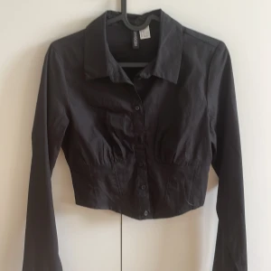 Croppad skjorta - Svart croppad skjorta från H&M 👚Aldrig använd 👚Nypris: 149kr 👚Stl 36
