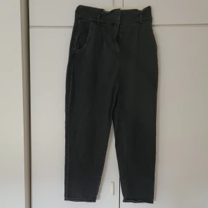 Svarta jeans - Svarta jeans från H&M i storlek 40. Högmidjade och 98 cm långa från midjan till benets slut. Innerbenslängden är ca. 65 cm. Fickor både fram och bak. Dragkedja och 2 knappar i fram. 