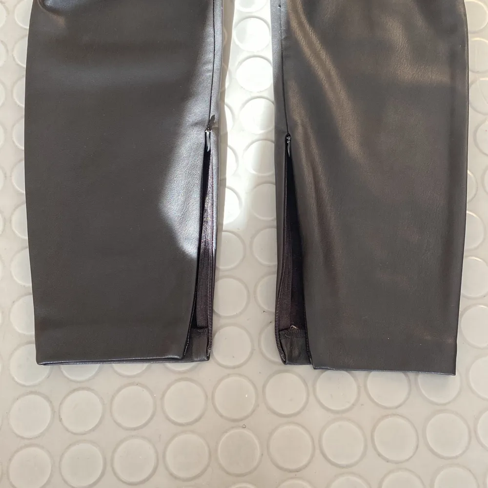 Svarta byxor med skinnimitation från Zara🖤Väldigt bra skick. Knappt använda. Byxorna har dragkedjor längst ner som man kan stänga om man vill. Storlek: M.. Jeans & Byxor.