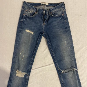 Gina tricot- kristen jeans 27/30 - Snygga jeans från Gina tricot med dragkedja nertill på benen som man inte ser på bilderna. Stl 27/30. Endast använda fåtal gånger, nyskick. 