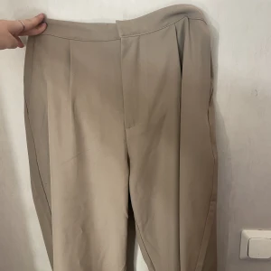 Kostymbyxor  - Beiga kostymbyxor från lager 157. Som jag sytt upp. Jag är 163 och dem passar mig nu efter jag sytt upp dem.