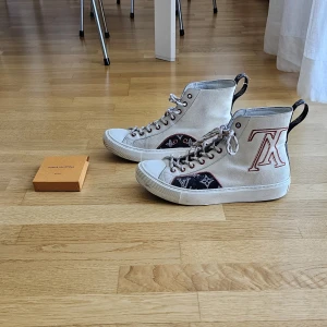 Louis Vuitton sneakers - Louis vuitton sneakers, Storlek 40. De är använda och orginalskosnörena är trasiga men skickar med en extra förpackning med nya louis vuitton skosnören. Inköpspris ungefär 10 000. Nyputsade och vårdade hos skomakare.