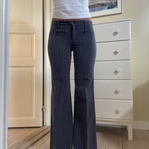 Lågmidjade går kostymbyxor  - Grå randiga lågmidjade kostymbyxor stl 36, midjemått 77cm innerbenslängd 78cm, jag är 173cm! Direktpris: 500kr