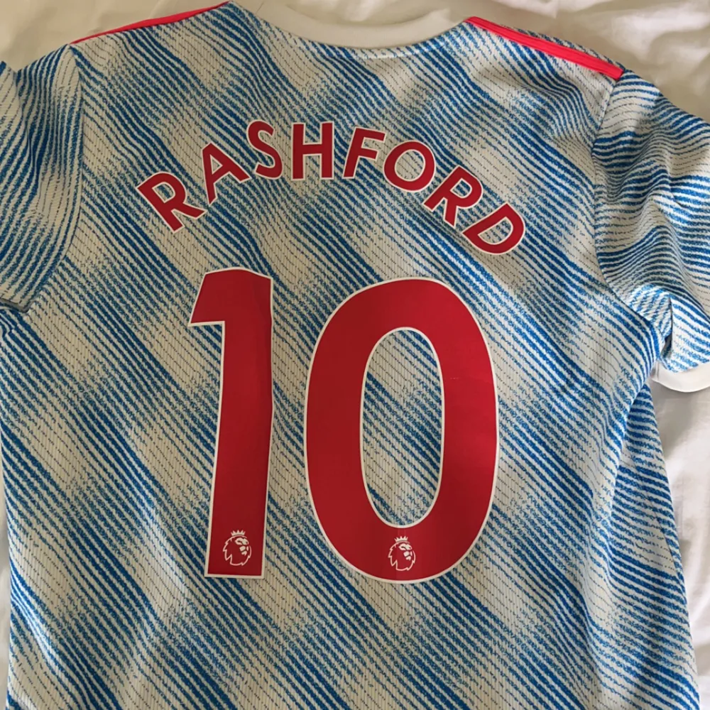 Säljer denna feta Manchester United bortatröja från säsongen 21/22 med Rashford #10 på ryggen. Köpt direkt från Uniteds hemsida och är i 10/10 skick. Storlek L och passar mig bra som är 189cm.. T-shirts.