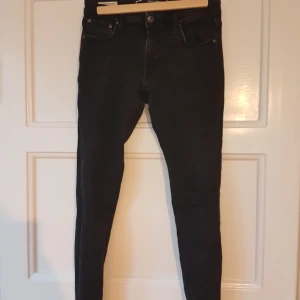 Svarta Jeans i strlk W29 L30, från Jack & Jones - Svarta jeans från Jack & Jones. Det är svårt att ta bild på dom, men tycker dom liknar perfectjeans. Väldigt sköna!   Hojta om ni vill ha fler bilder på något plagg!