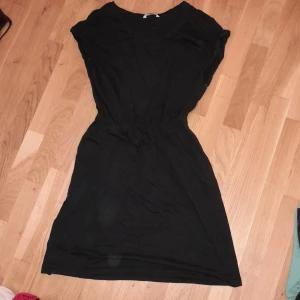 Klänning - klänning med fickor vid vardera höft, resorband vid midjan. Aldrig använd