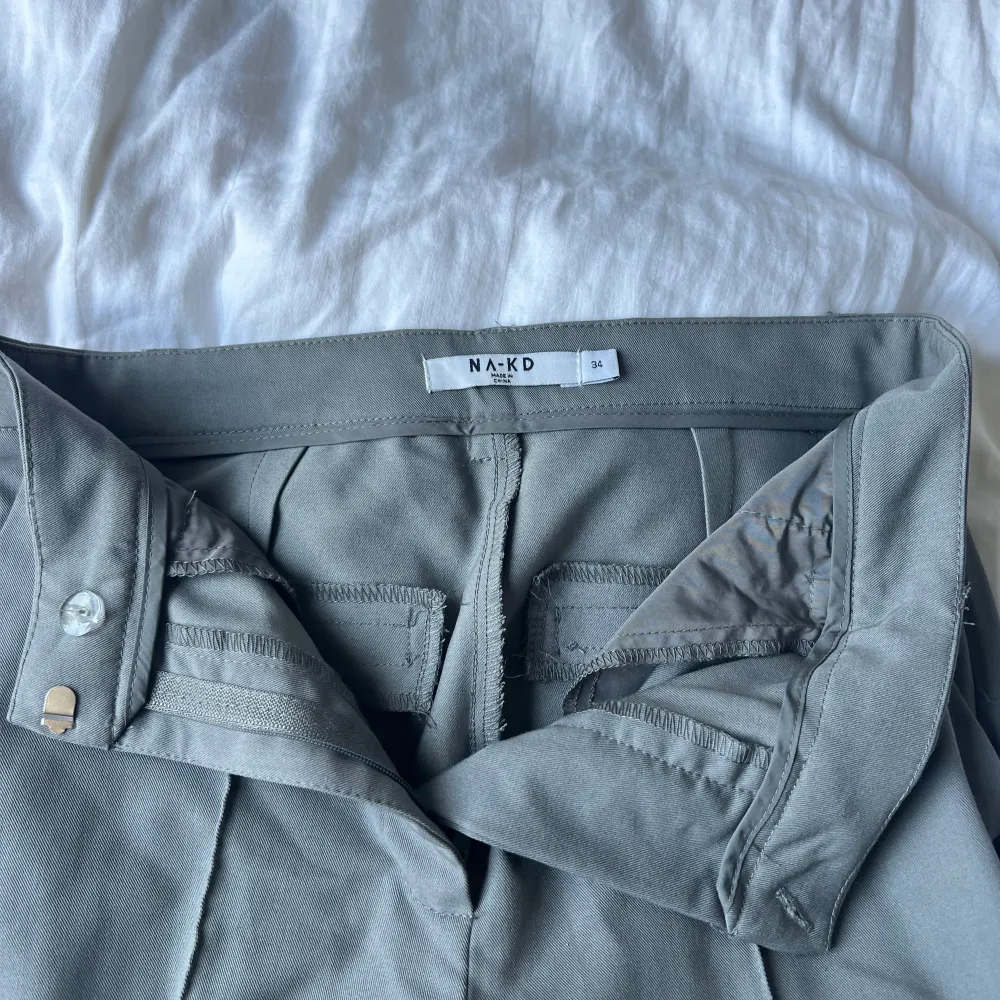gråa kostymbyxor med liten slits längst ner från NA-KD. Jeans & Byxor.