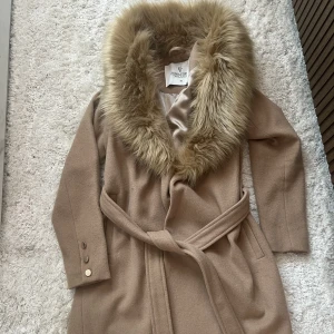 Kappa från Bubbleroom  - Säljer min fina kappa från Bubbleroom. Pälsen går att ta av. Nypris 1119kr. Storlek 36. I nyskick. 