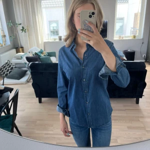 Jeansskjorta  - Mjuk jeansskjorta i stretchigt tyg. Knäpps med tryckknappar. 