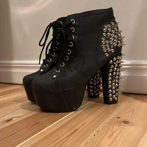 Jeffrey Campbell klackskor med nitar - De coolaste 90-tals klassikerna!! Som tyvärr inte blivit använda på år… de har hög klack och platå framtill och är otippat sköna och lätta att gå i!! Hela skon är i läder, med snörning framtill och nitar på klacken och hälen! Storlek 38!