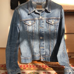 Vintage Denimjacka - Mått: Längd från krage till midja 60cm och armlängd är också runt 60cm.   Kan bäras med ett par beiga byxor eller ett par jeans och den funkar oftast att bäras med vad som helst.  Jackan har jättefina fades och är i väldigt bra skick.  