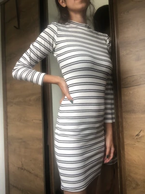 Randig bodycon-klänning - Vit och mörkblå randig klänning i bomull. Trekvartsärm, kroppsnära. Både snygg och skön