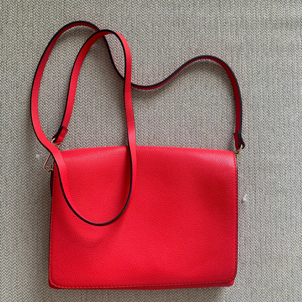 Röd axelremsväska från H&M, aldrig använt! . Väskor.
