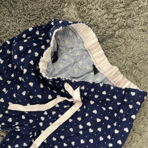”Pyjamasbyxor”  - Mörkblåa med små hjärtan.  Resor i midjan.  Inköpt på H&M.  Storlek L men känns som en M. 