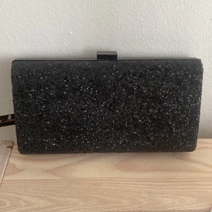 Aftonväska /glittrig clutch  - Glittrig clutch/aftonväska, perfekt när man vill ha en mindre finväska på fest!  Aldrig använd, prislappen är kvar. 