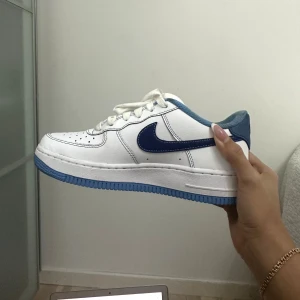 AIR FORCE 1'07 - Snygga airforce med blått nike märke och sula, den lilla metallbiten fram är guldig. I princip nya, använda 2 gånger då jag köpte de under vintern. Säljer då jag inte använder de. Väldigt bekväma, som vanliga airforce. 