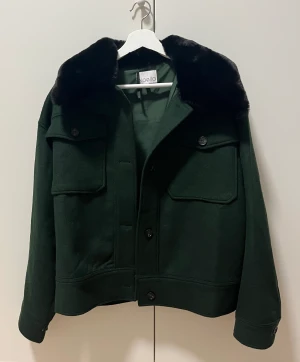 Meotine liknande jacka  - Mörkgrön Meotine liknande jacka från Noella. Storlek S. Svart fuskpäls. Endast använd ett fåtal gånger. 