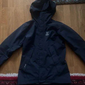 haglöfs jacka - säljer min mörkblåa haglöfs jacka i storlek S men passar även M. Skick 9/10 använd max 5 gånger. vatten & vind tät🤝🏽 Nypris: 1500 mitt pris: 800kr