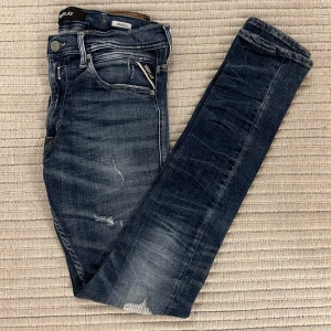Replay Jeans - Säljer dessa Replay jeans i modellen Jondrill som liknar Anbass, slim fit. De är i en snygg tvättat blå färg med fräscha slitningar! Storleken är W31L31. Nypris: ca 1850kr, Mitt pris: 499kr! Hör av er vid frågor eller funderingar!